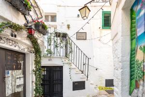 a building with stairs and a door and flowers at Casa Agata Cisternino in Cisternino