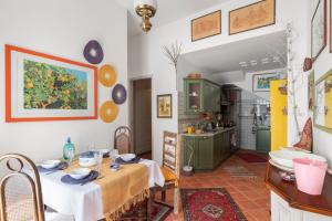 a dining room with a table and a kitchen at Casina di Marnie in Balestrate