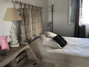a bedroom with a bed and a table with a lamp at Maison Amalur in Arcangues