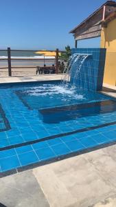 a blue tile pool with a water fountain at Casa Amarela - Guajiru in Trairi