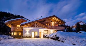 a log home in the snow at night at Piciulei Pitl in Selva di Val Gardena