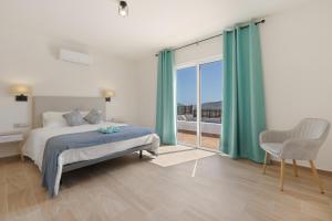 a bedroom with a bed and a large window at Rincón del olivar in Fuerteventura