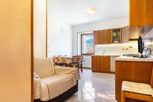 a kitchen and living room with a couch and a table at Appartamenti l'Edera in Cavedago