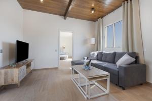 a living room with a couch and a tv at Rincón del olivar in Fuerteventura