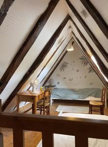 a attic room with a bed and a table and chairs at Gîte Rosa Bonheur in Saint-Cernin