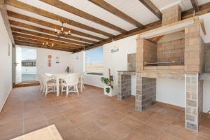 a living room with a fireplace and a table and chairs at Rincón del olivar in Fuerteventura