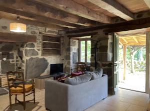 a living room with a couch and a desk at Gîte Rosa Bonheur in Saint-Cernin