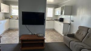 a living room with a couch and a flat screen tv at Amble Inn in Warwick