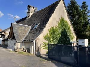 an old house with a black fence in front of it at Gîte Rosa Bonheur in Saint-Cernin
