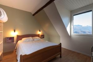 a bedroom with a bed with a large window at Gite du Pibeste - 8 pers in Ouzous