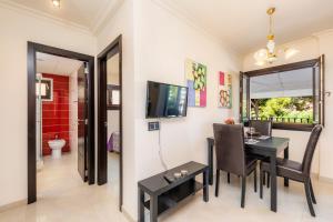 a dining room with a table and chairs and a television at Neo in Cala Ratjada