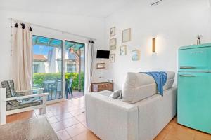 a living room with a couch and a refrigerator at Sa Calma House in Cala en Bosc