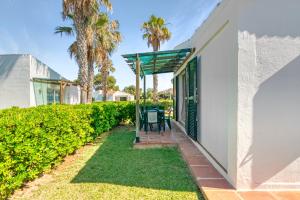 a patio with a table and chairs next to a building at Sa Calma House in Cala en Bosc