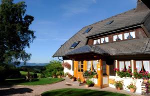 a house with a black roof and flowers inpots at Haus Scherer in Sankt Peter