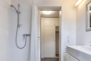 a white bathroom with a shower and a sink at Ferienwohnung Lumafe in Überlingen +13 photos