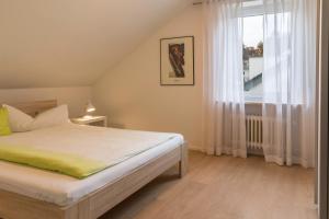 a bedroom with a bed and a large window at Ferienwohnung Lumafe in Überlingen