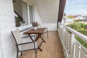 a balcony with a wooden table and chairs on a porch at Ferienwohnung Lumafe in Überlingen