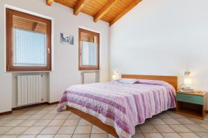 a bedroom with a bed and two windows at Rustico Spagnol 4 in Tignale