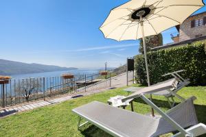 a patio with a chair and an umbrella at Rustico Spagnol 4 in Tignale