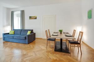 a living room with a table and a blue couch at Ferienwohnung Daniela in Merano