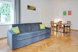 a blue couch in a living room with a table at Ferienwohnung Daniela in Merano +16 photos