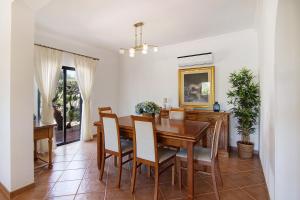 a dining room with a wooden table and chairs at Villa Formosa in Almancil