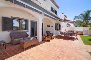 a patio with a couch and a table and chairs at Villa Formosa in Almancil