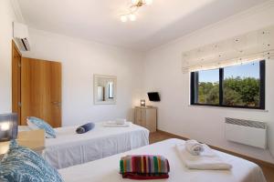 a white room with two beds and a window at Villa Formosa in Almancil +27 photos