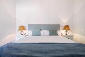 a bedroom with a large bed with two lamps at Las Raíces in Pájara