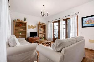 a living room with two white couches and a tv at Las Raíces in Pájara