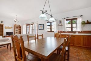 a kitchen and dining room with a wooden table and chairs at Las Raíces in Pájara