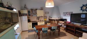 a kitchen with a table and chairs and a television at Podere Le Palme in Castiadas