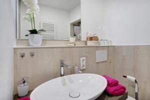 a bathroom with a white sink and a pink towel at Ferienwohnung Marinas Alpenblick in Inzell
