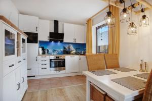 a kitchen with white cabinets and a table with chairs at Ferienwohnung Marinas Alpenblick in Inzell +20 photos