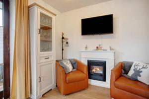 a living room with two chairs and a fireplace at Ferienwohnung Marinas Alpenblick in Inzell
