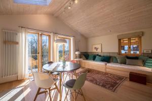 a living room with a couch and a table and chairs at Ferienwohnung Bei der Töpferei in Pittenhart
