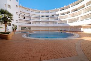 a large building with a large swimming pool in a courtyard at Apartamento Nautilus in Armação de Pêra +16 photos