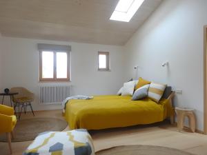a bedroom with a bed with a yellow blanket at Ferienwohnung Bei der Töpferei in Pittenhart