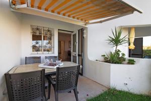 a patio with a table and chairs and a plant at Apartamento Nautilus in Armação de Pêra