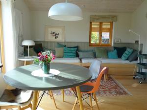a living room with a table and a couch at Ferienwohnung Bei der Töpferei in Pittenhart +23 photos