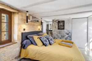 a bedroom with a large yellow bed with pillows at L'Annexe Gîte Premium in Groléjac