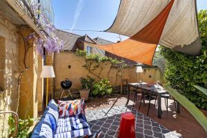 an outdoor patio with a couch and a table at L'Annexe Gîte Premium in Groléjac