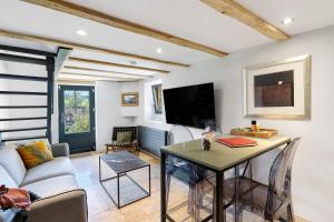 a living room with a table and a tv at L'Annexe Gîte Premium in Groléjac