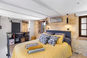 a bedroom with a yellow bed with pillows on it at L'Annexe Gîte Premium in Groléjac