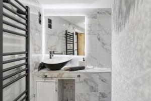 a white bathroom with a sink and a mirror at L'Annexe Gîte Premium in Groléjac +18 photos