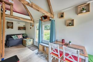 a living room with a table and chairs and a couch at Le chouette insolite in Cresseveuille