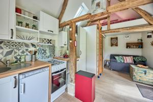 a kitchen with white cabinets and a red refrigerator at Le chouette insolite in Cresseveuille