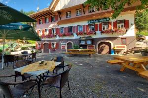 a group of tables and chairs in front of a building at Gasthaus Zur Linde Ferienwohnungen in Oberharmersbach