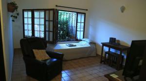a room with a bed and a chair and a window at El Aromito in Jesús María