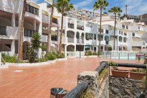 a courtyard of a building with palm trees at Villa Amanda in Playa del Cura